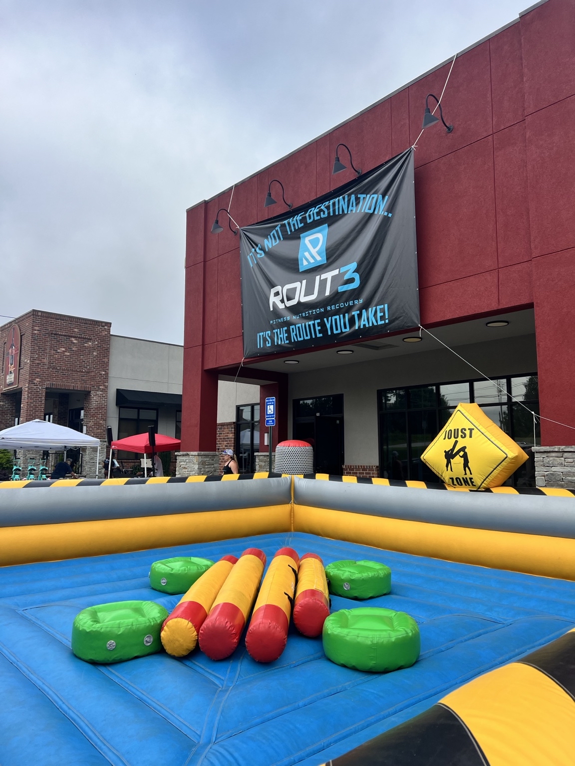 Route 3 Fitness signage behind a colorful joust attraction