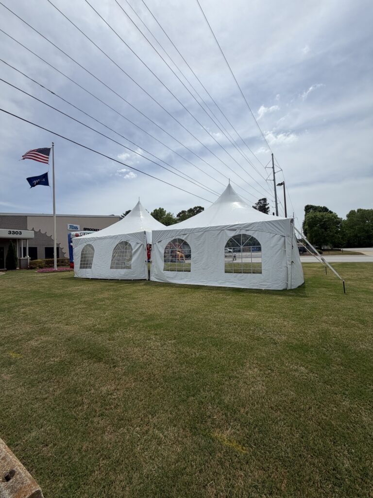 White high-peak tent enclosed with window sidewalls on grass