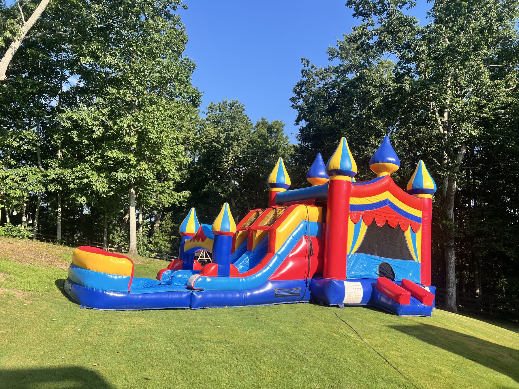 Classic castle bounce and slide combo professionally installed on grass