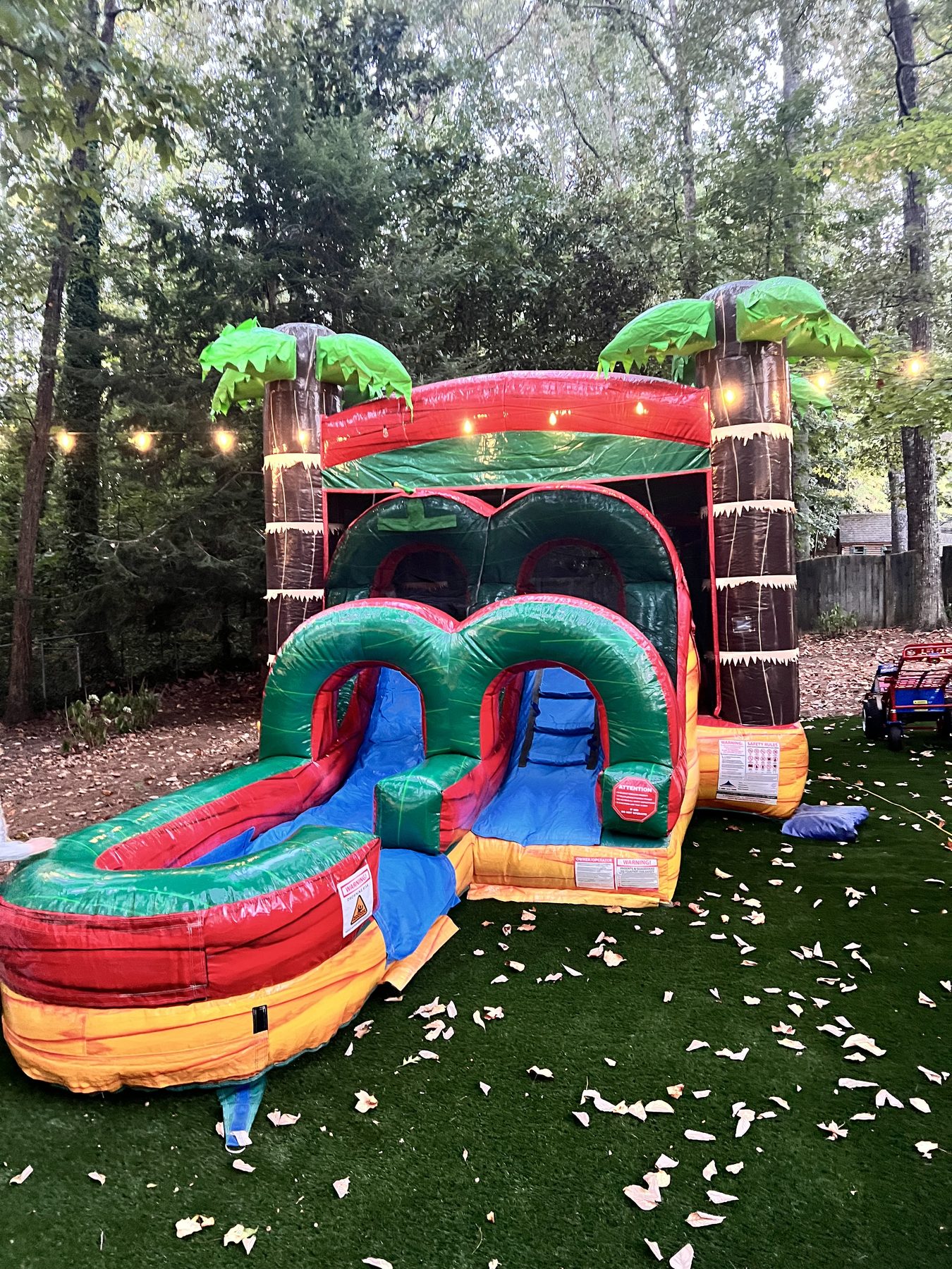 Tropical bounce and slide combo installed in a backyard
